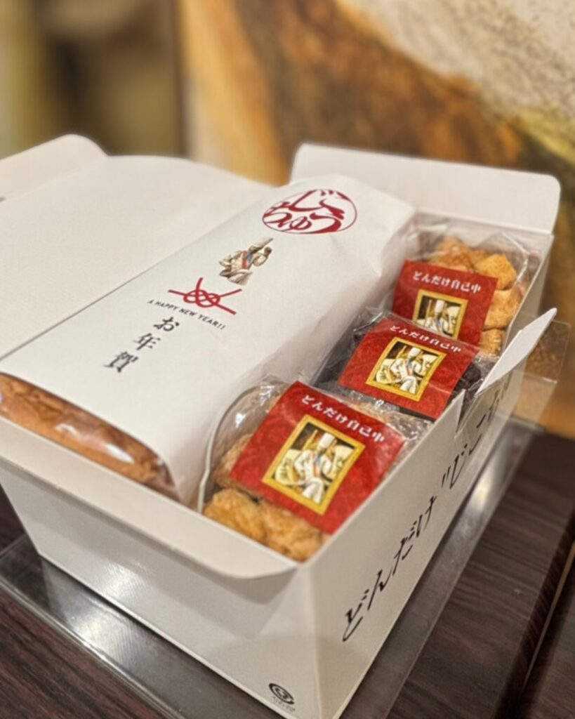 どんだけ自己中 羽村店のギフトBOX。食パンと個包装の焼き菓子を詰め合わせ、お年賀の掛け紙付き