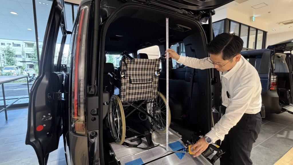 Honda Cars 東京西 さくらモール羽村店のスタッフが、ステップ ワゴン 車いす仕様車の後部開口部の高さをメジャーで測っているところ