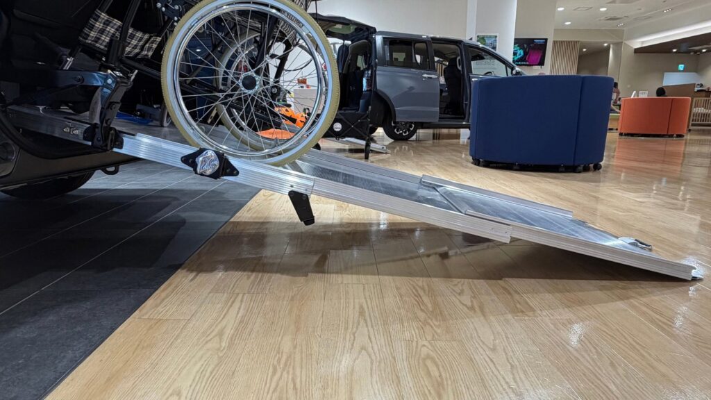 FREED CROSSTAR 車いす仕様車のスロープに車いすを乗せているところ（さくらモール羽村店）
